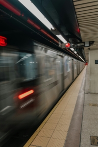 New York City subway train passing through a Brooklyn station, representing The Shop Brooklyn's Subway Reads book series for commuters.
